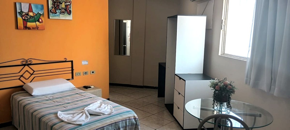 Quarto simples do Hotel Frontal da Serra — cama individual, ar condicionado e mesa de trabalho